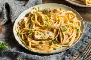 Creating creamy Alfredo sauce for Cajun pasta. Finished Cajun Chicken Alfredo dish ready to serve.