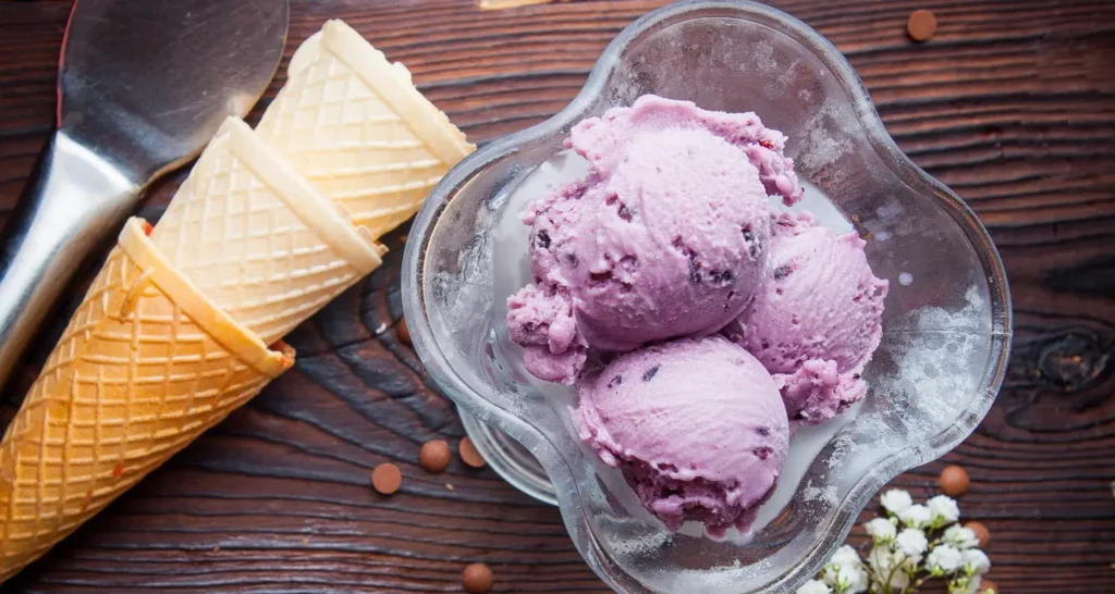 For an image of a bowl of ube ice cream: Alt: "Bowl of creamy ube ice cream" Synonym Alt: "Scoops of purple yam dessert in a bowl" For an image showing the ube ice cream making process: Alt: "Making homemade ube ice cream" Synonym Alt: "Preparing Filipino ice cream with purple yam" For an image of ube yams: Alt: "Fresh ube yams for dessert" Synonym Alt: "Purple yams used in ube dessert" For an image of ube desserts variety: Alt: "Assorted ube desserts on display" Synonym Alt: "Variety of purple yam dessert options" For an image of ube ice cream served with toppings: Alt: "Ube ice cream topped with coconut flakes" Synonym Alt: "Gourmet Filipino ice cream with toppings"